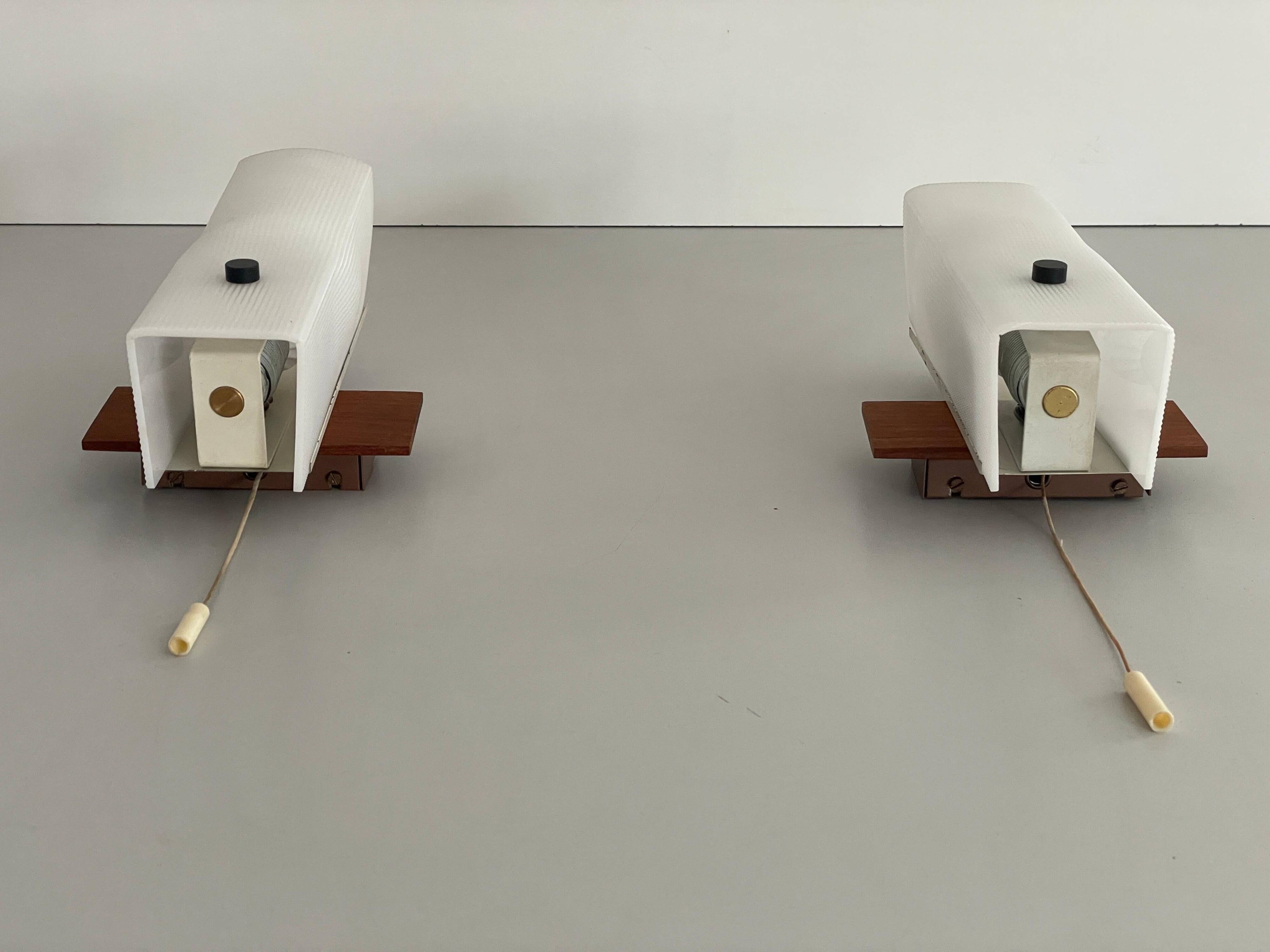 Mid-century wall lights in white plexiglass with a wooden base, 1960s, Germany.
