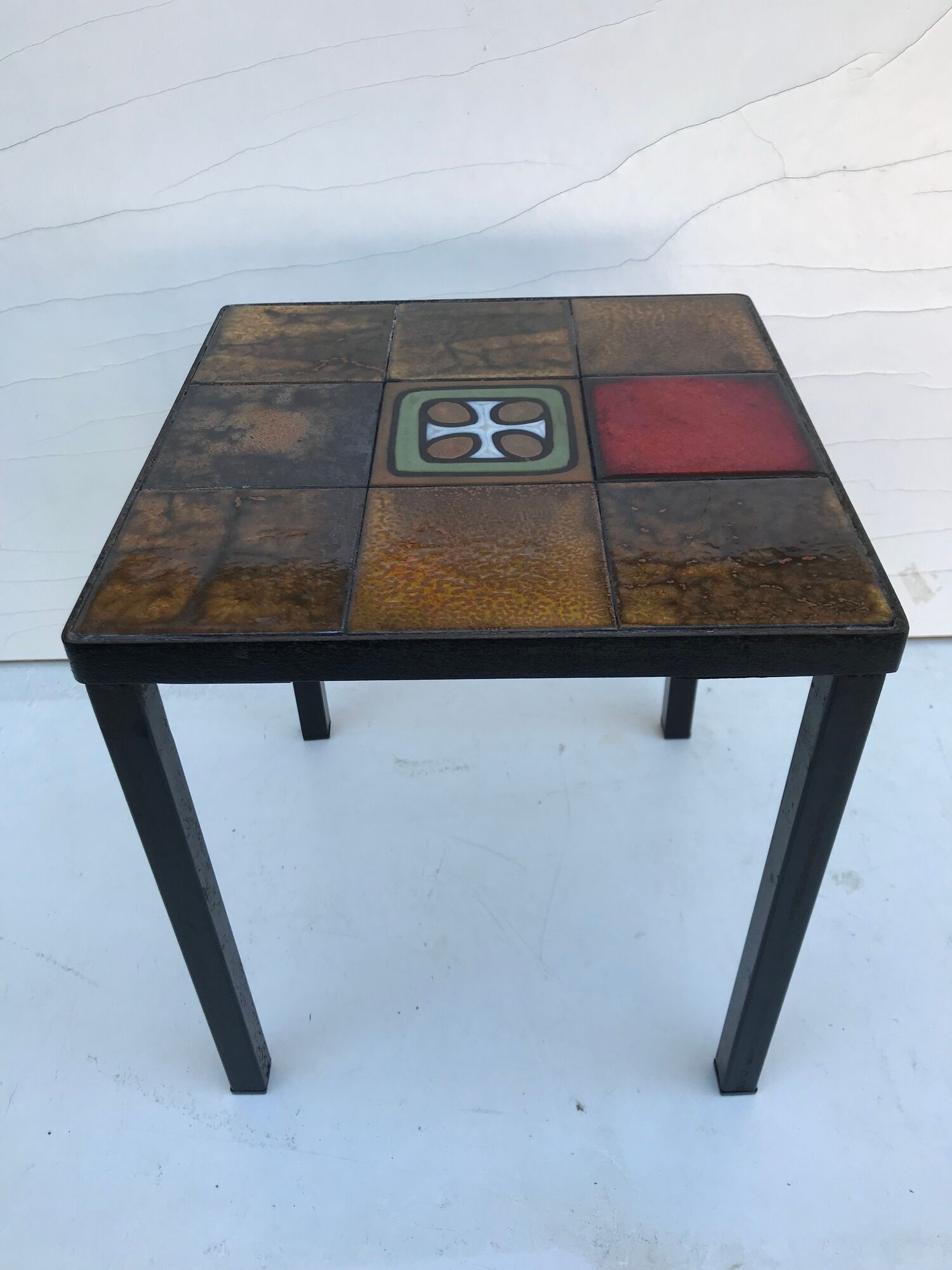 Old black metal and majolica tiles table