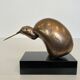 Bronze sculpture representing a stylised bird on a black marble base, signed and numbered.