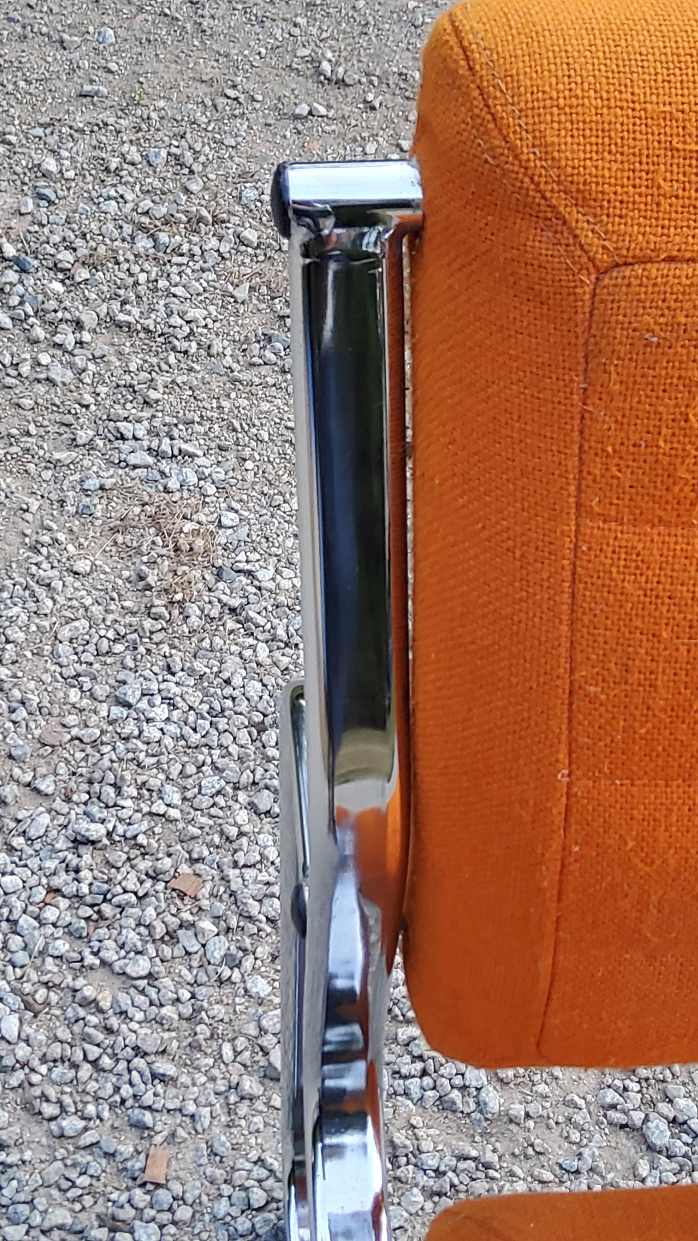 Pair of designer armchairs in orange fabrics and chrome tubes from the 70s