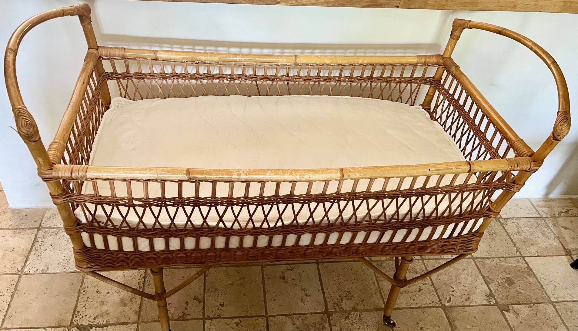 Vintage rattan baby bed with wheels