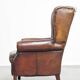 Fauteuil à oreilles confortable et bien entretenu en cuir de mouton