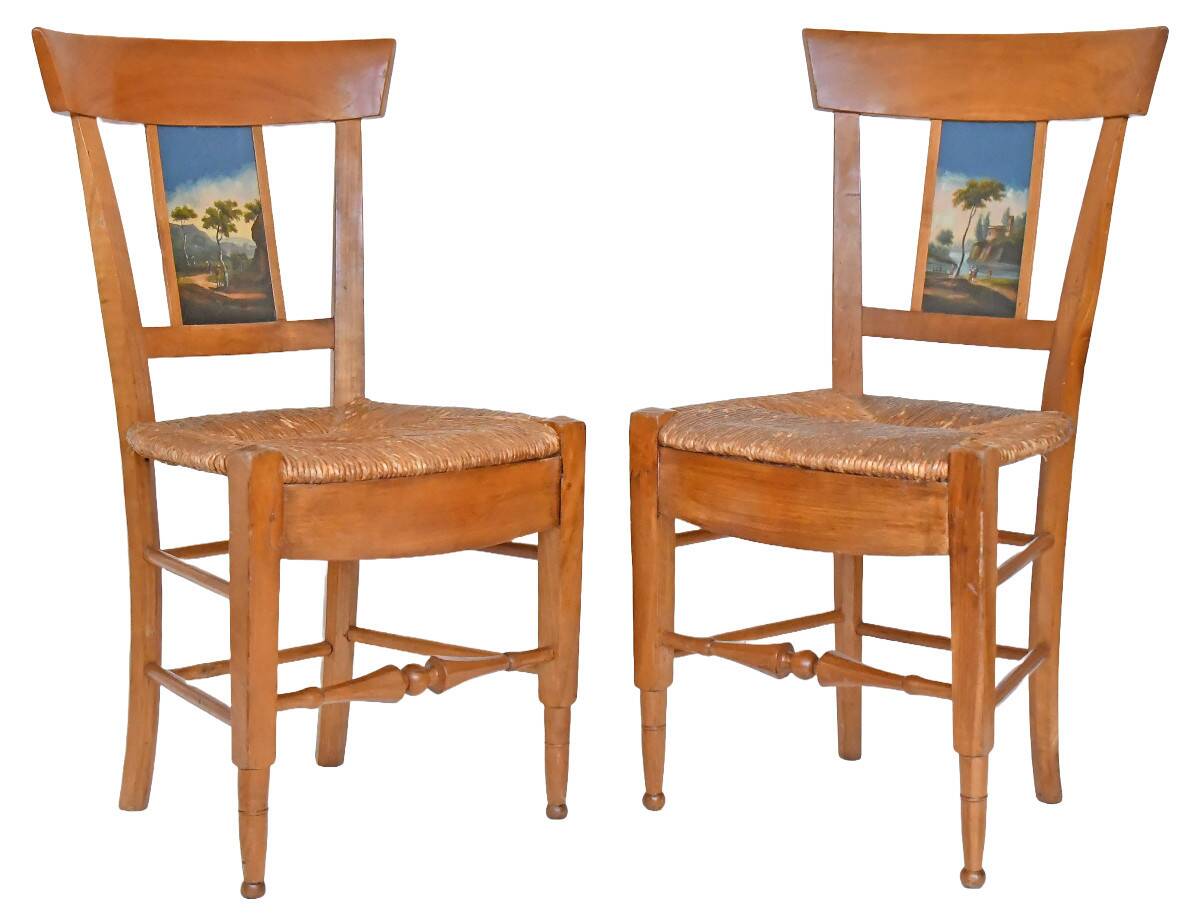 Pair of chairs with slatted backs and painted bands depicting animated landscapes.