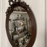 Antique oval mirror in carved wood and Louis XVI style knot