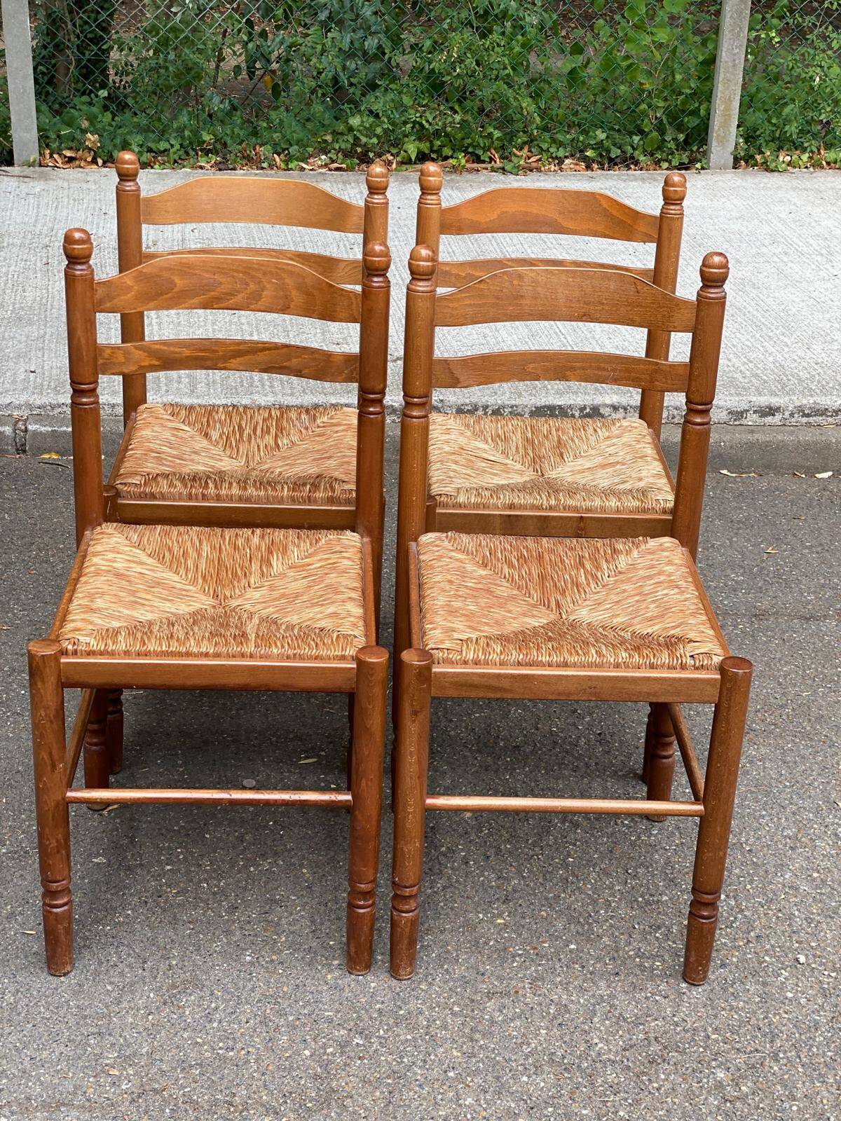 4 solid wood kitchen chairs with straw seats in a country farmhouse style.