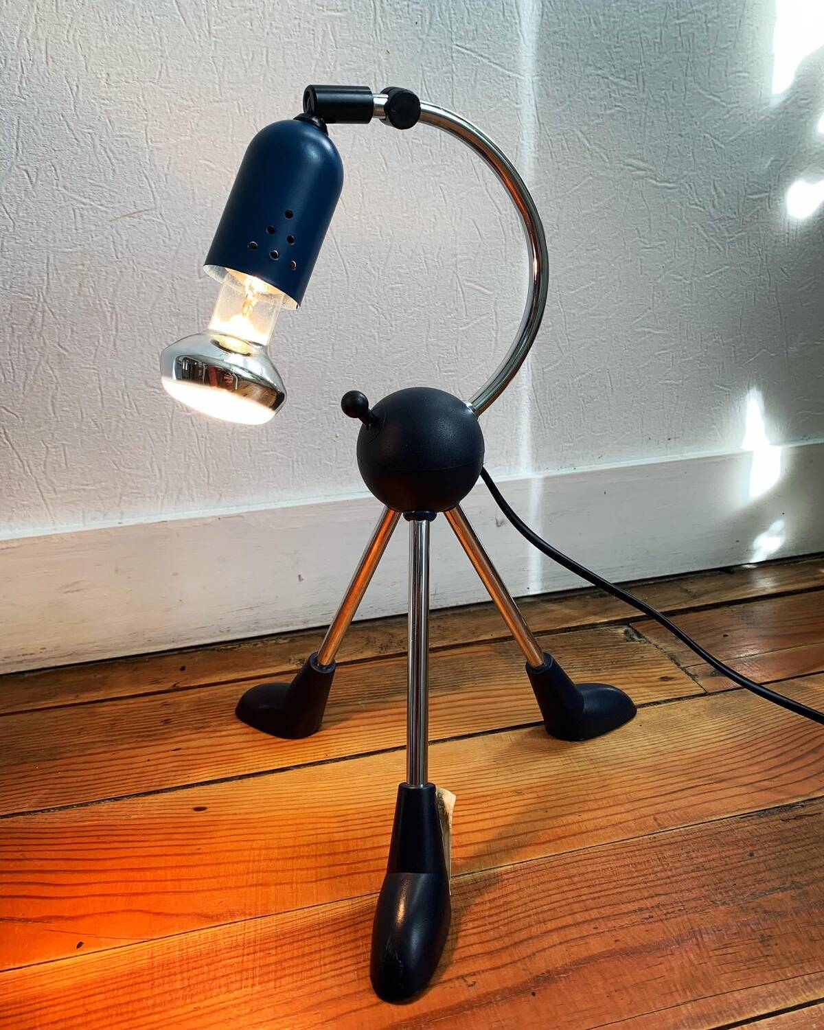 Articulated tripod foot lamp inspired by the Memphis movement