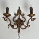 Pair of patinated wrought iron wall sconces with golden acanthus leaves and crystals.