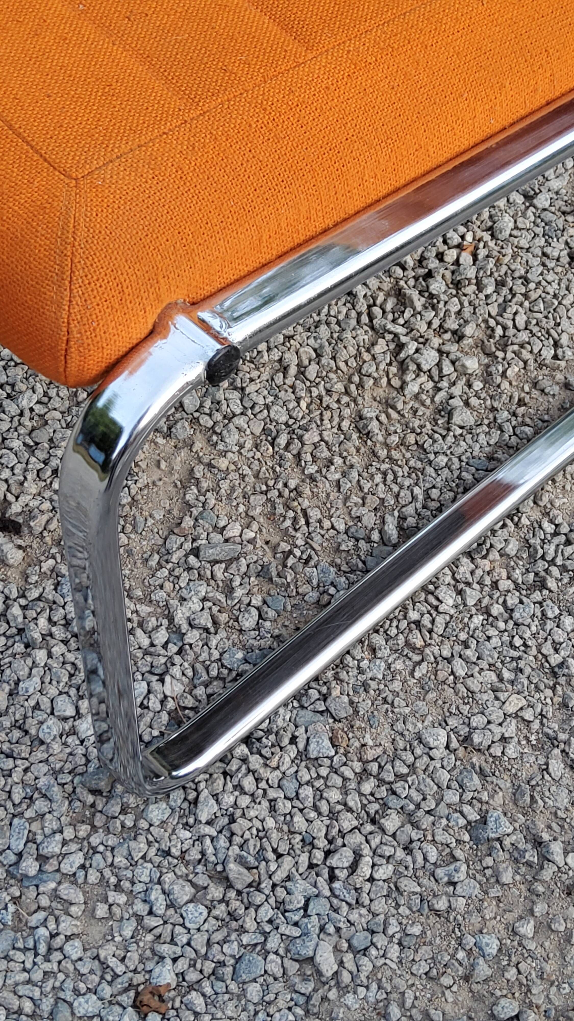 Pair of designer armchairs in orange fabrics and chrome tubes from the 70s