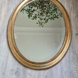 Oval mirror beveled gilded, wooden frame and stucco