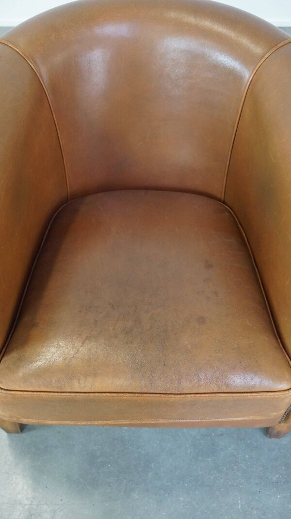 Fauteuil club en cuir de mouton de couleur cognac neutre et en bon état