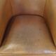Fauteuil club en cuir de mouton de couleur cognac neutre et en bon état