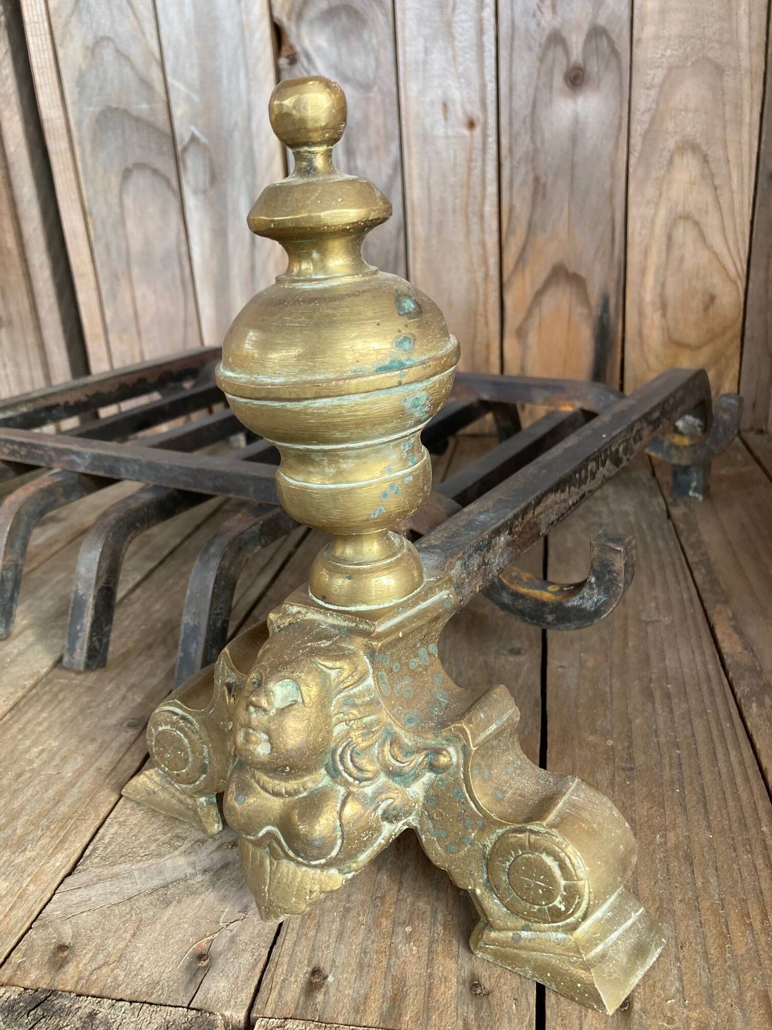 Pair of andirons and grates in cast iron and bronze with gilded grotesques, 17th century