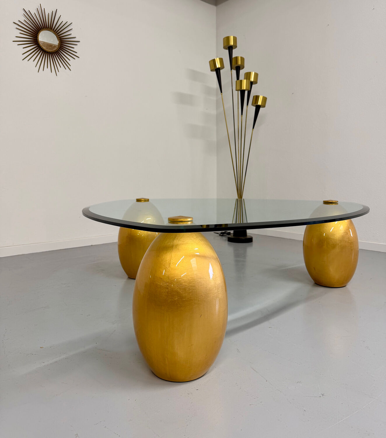 Vintage Italian design coffee table with a glass top and gold base, dating from the 1980s.