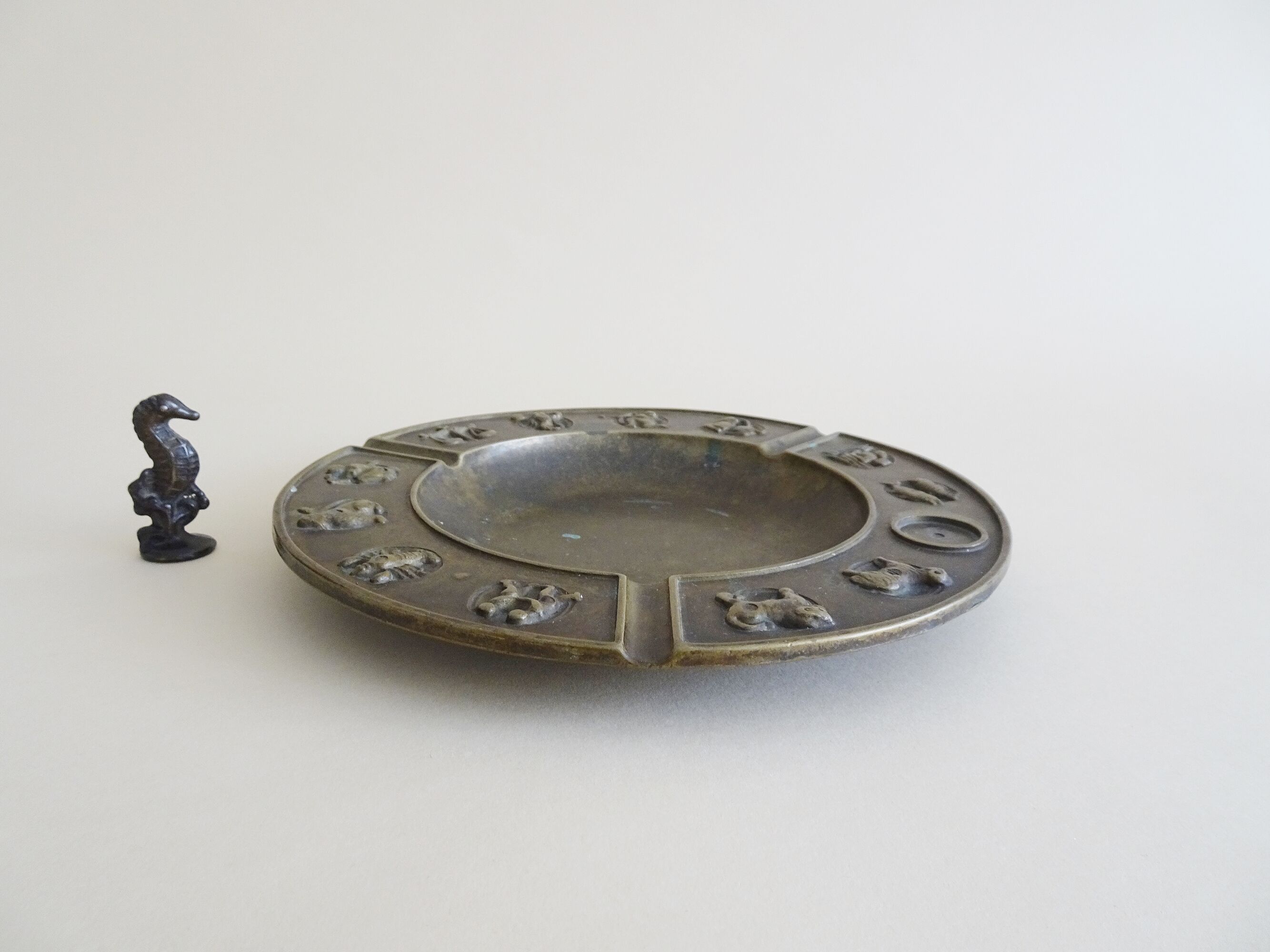 Luxa brass ashtray with zodiac relief and embers killer