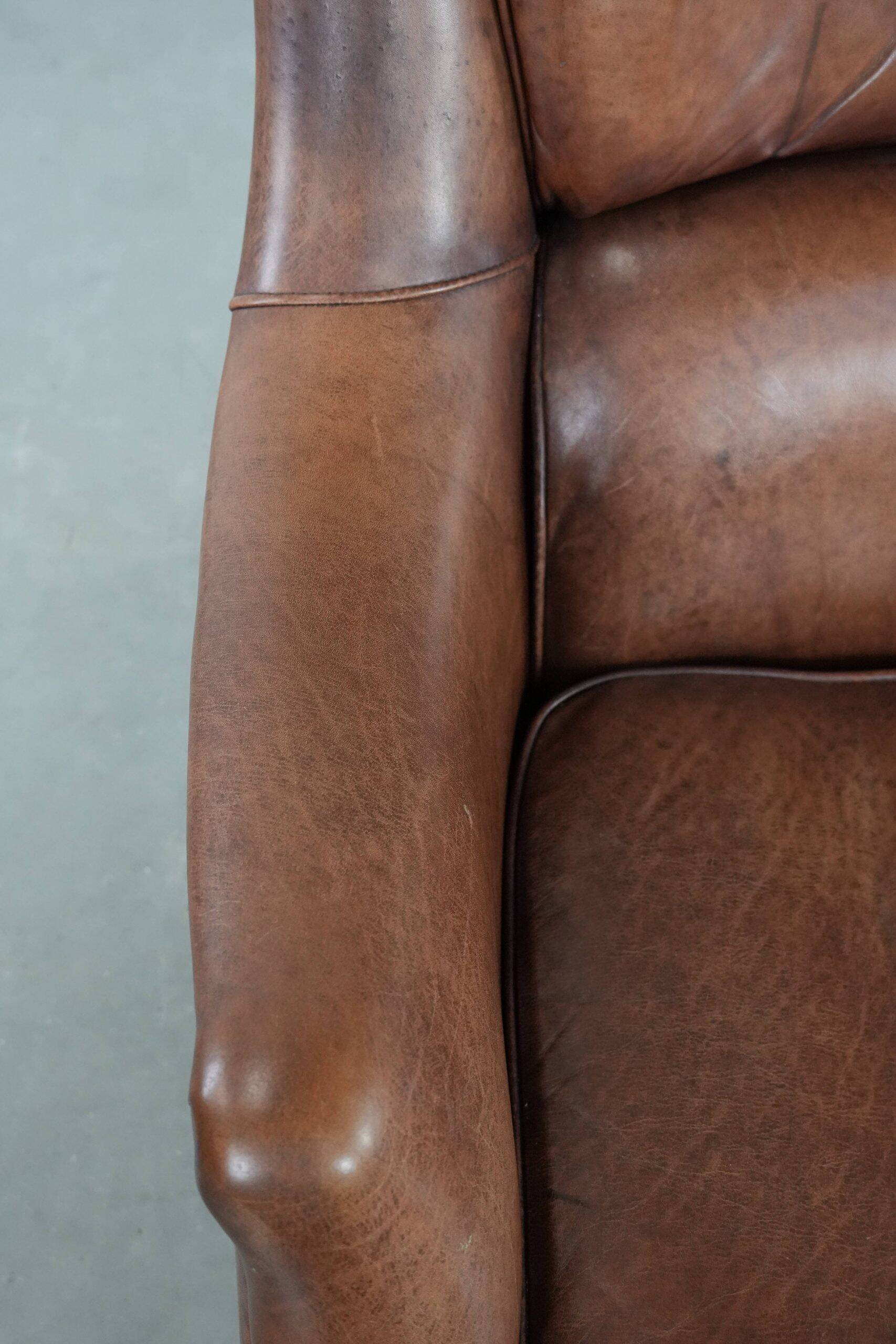 Cognac brown cow leather armchair with decorative nail finish