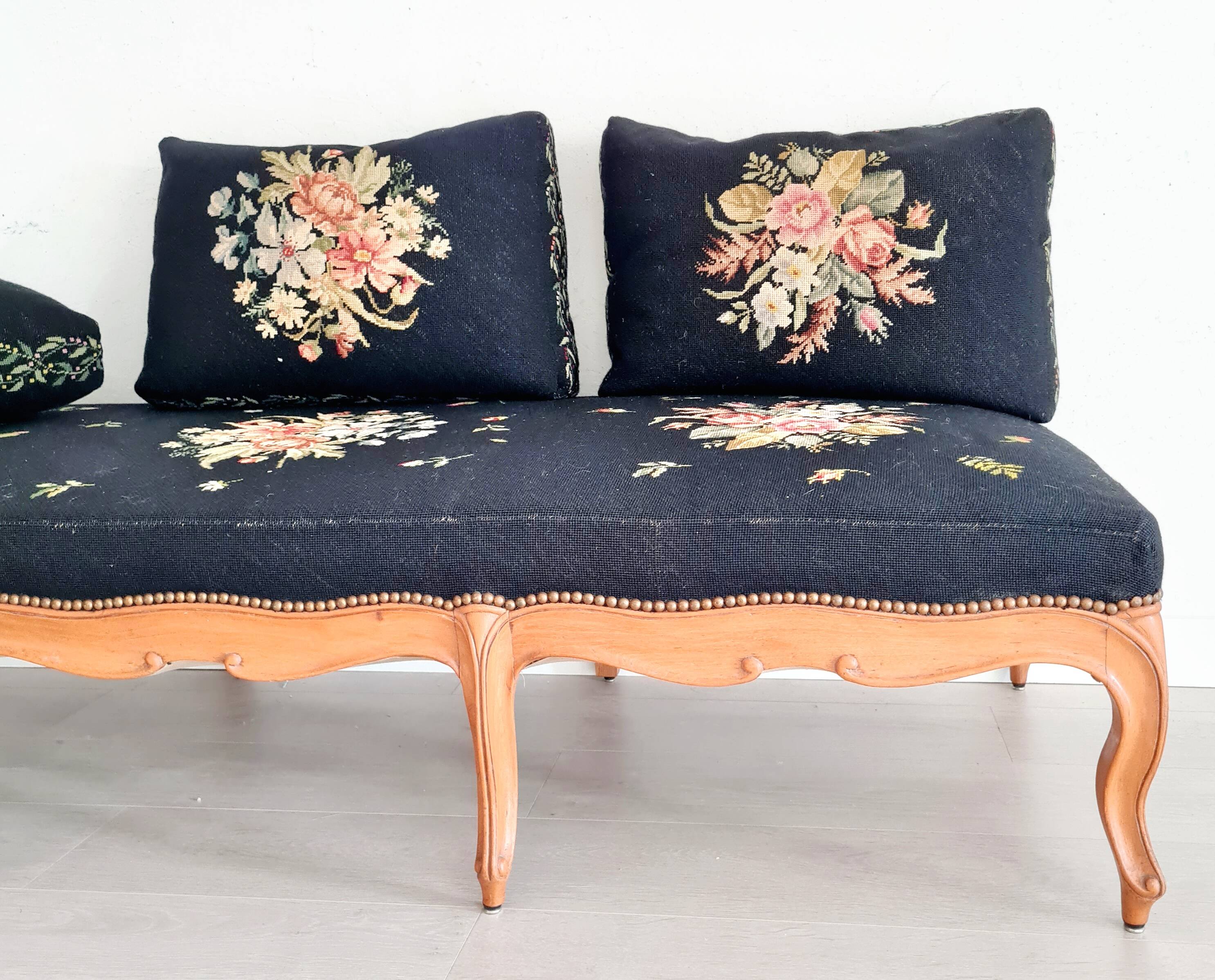 Old bench upholstered in black canvas flowers