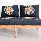 Old bench upholstered in black canvas flowers