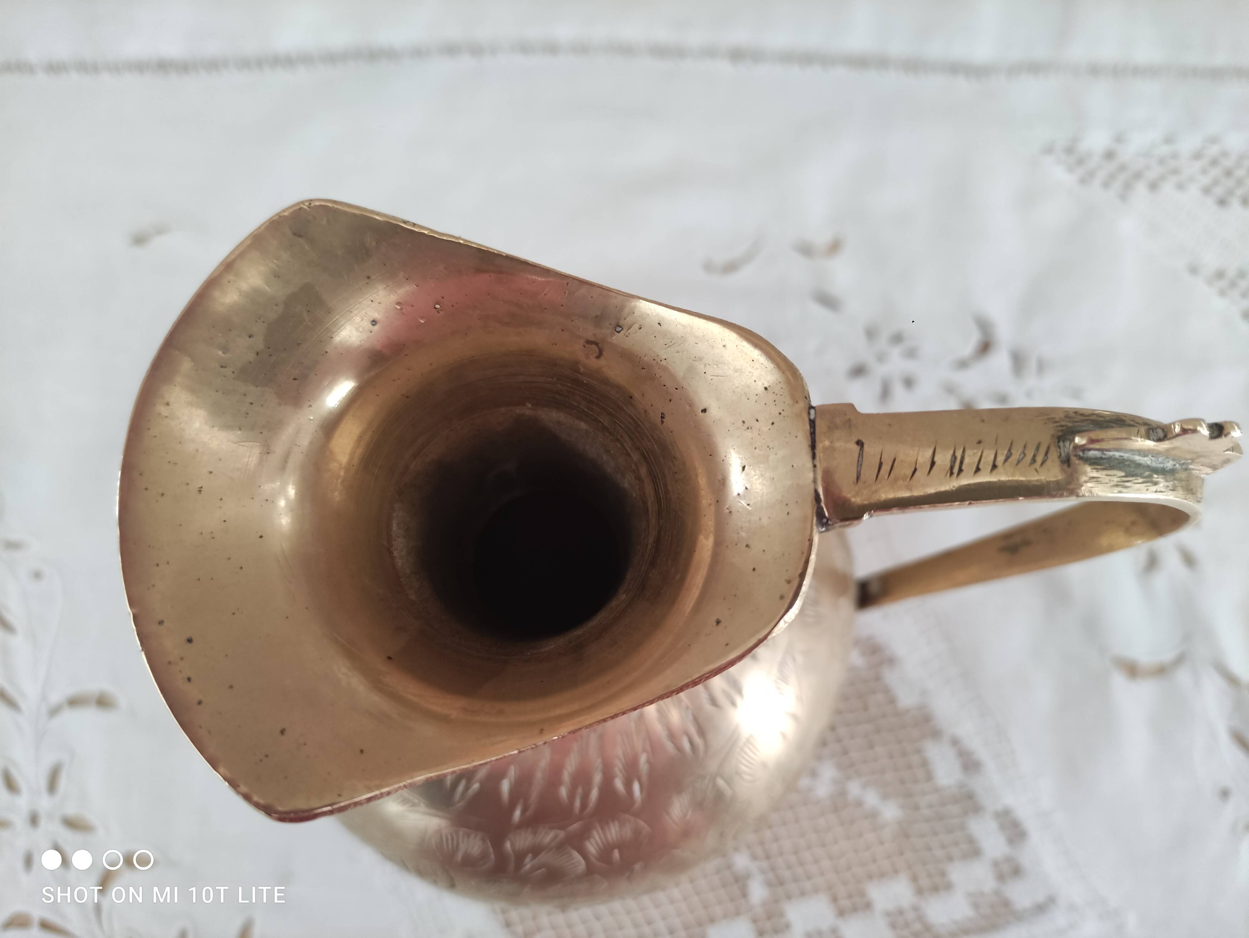 Chiseled brass pitcher decorated foliage