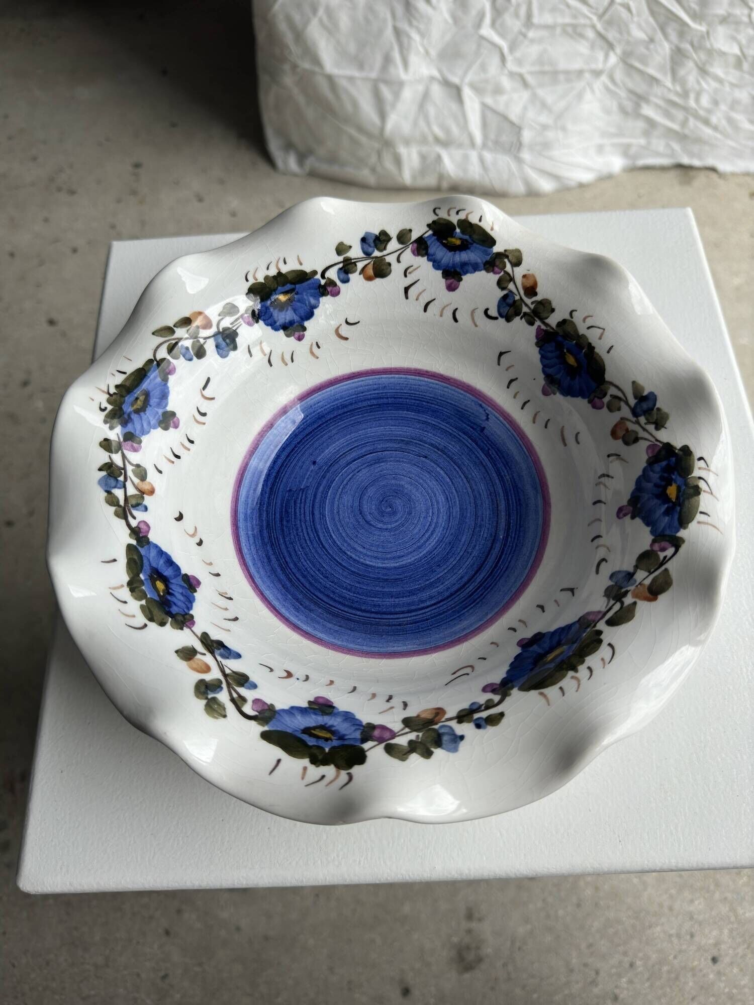 Small hand-painted earthenware salad bowl with garland of blue flowers, mark below
