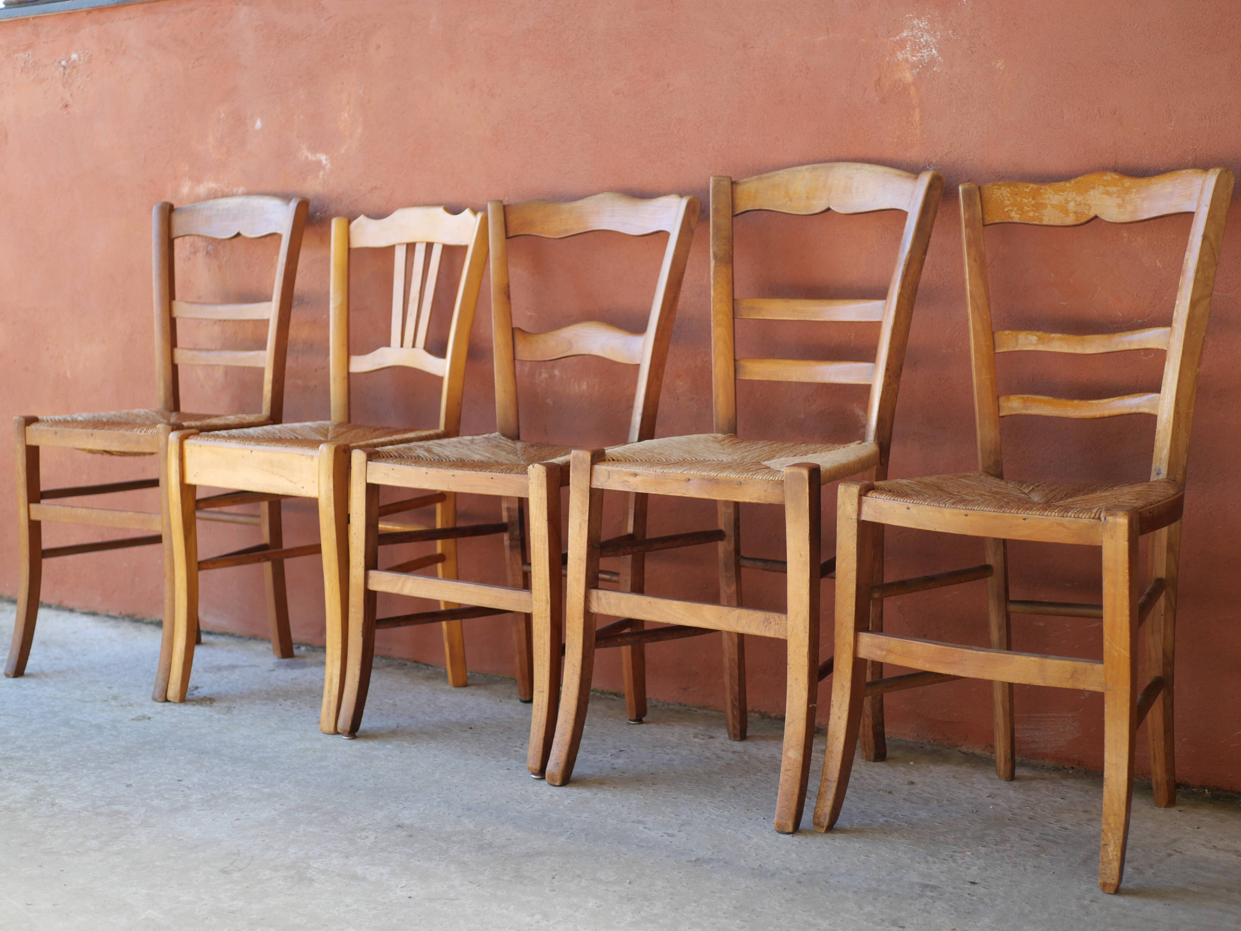 Set of 5 mismatched straw chairs.