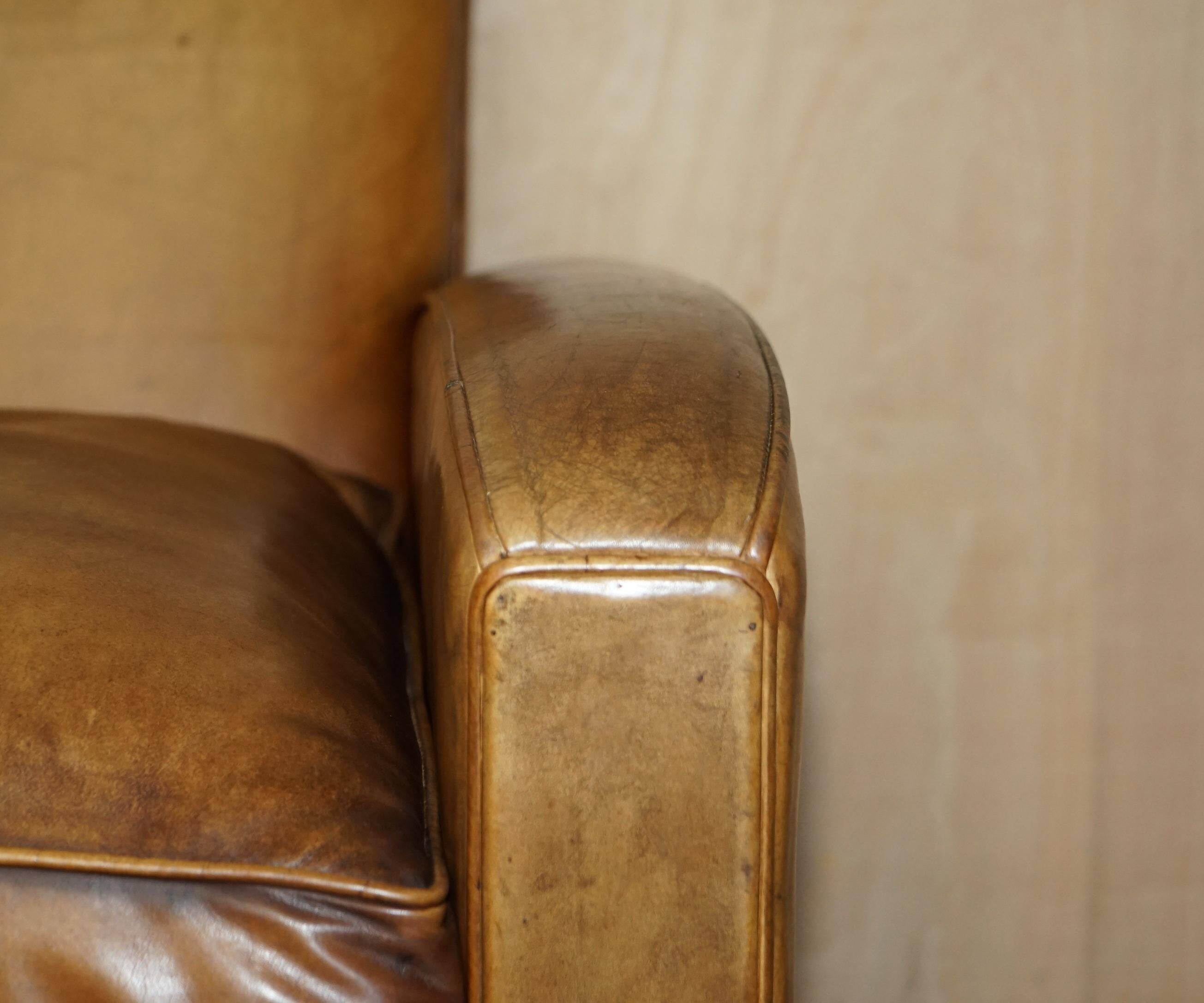 Three-seater Art Deco style leather sofa with feather cushions.
