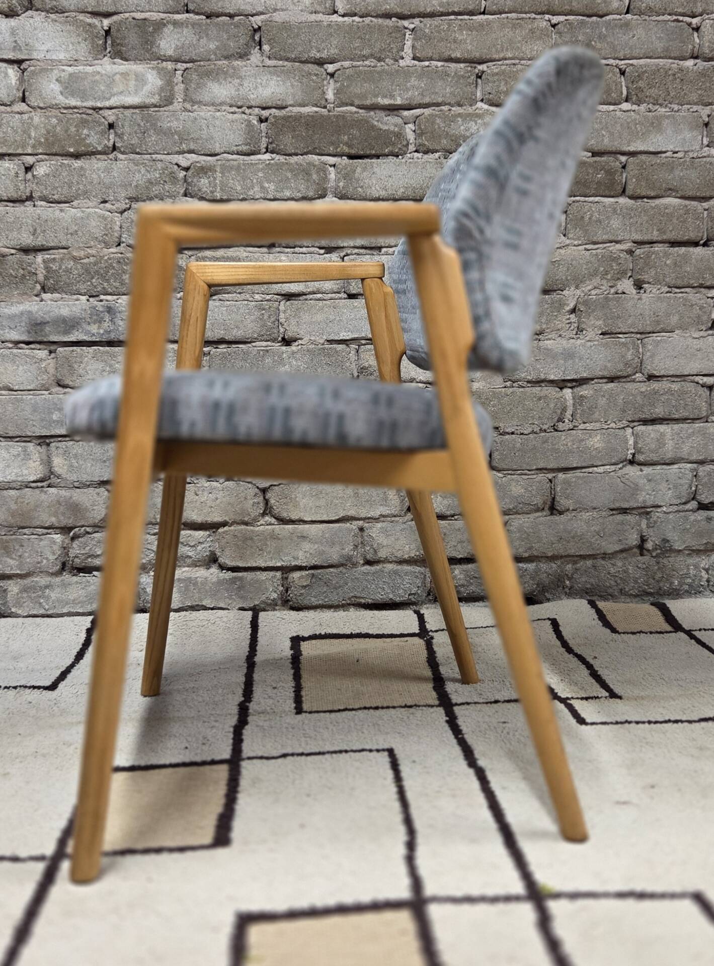 Vintage armchair from the 60s/70s in wood and grey fabric – with armrests.