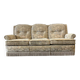 Vintage beige three-seater sofa with floral pattern and fringes.