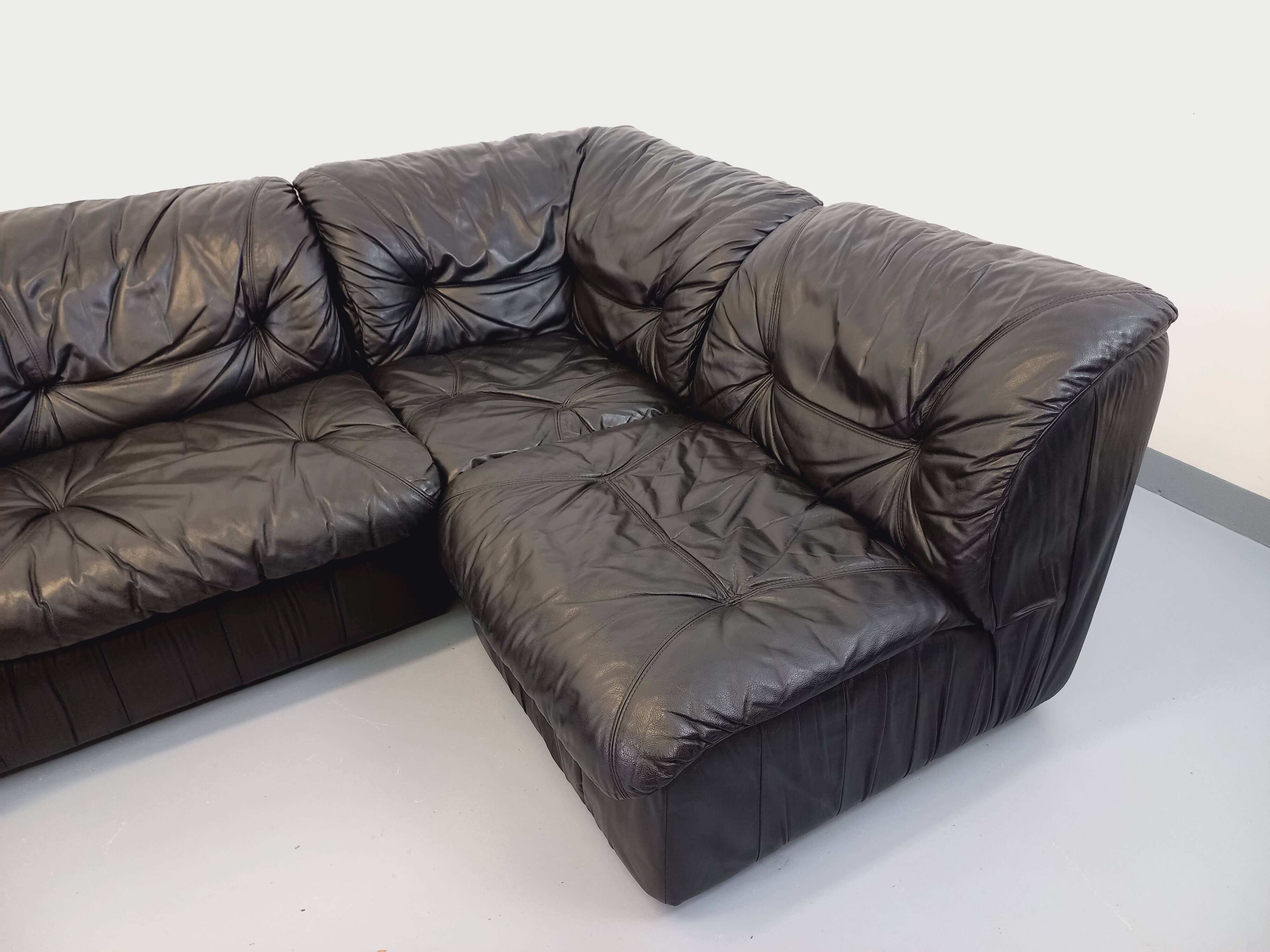 Vintage corner sofa composed of 3 modules in black leather with integrated bed.