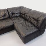 Vintage corner sofa composed of 3 modules in black leather with integrated bed.