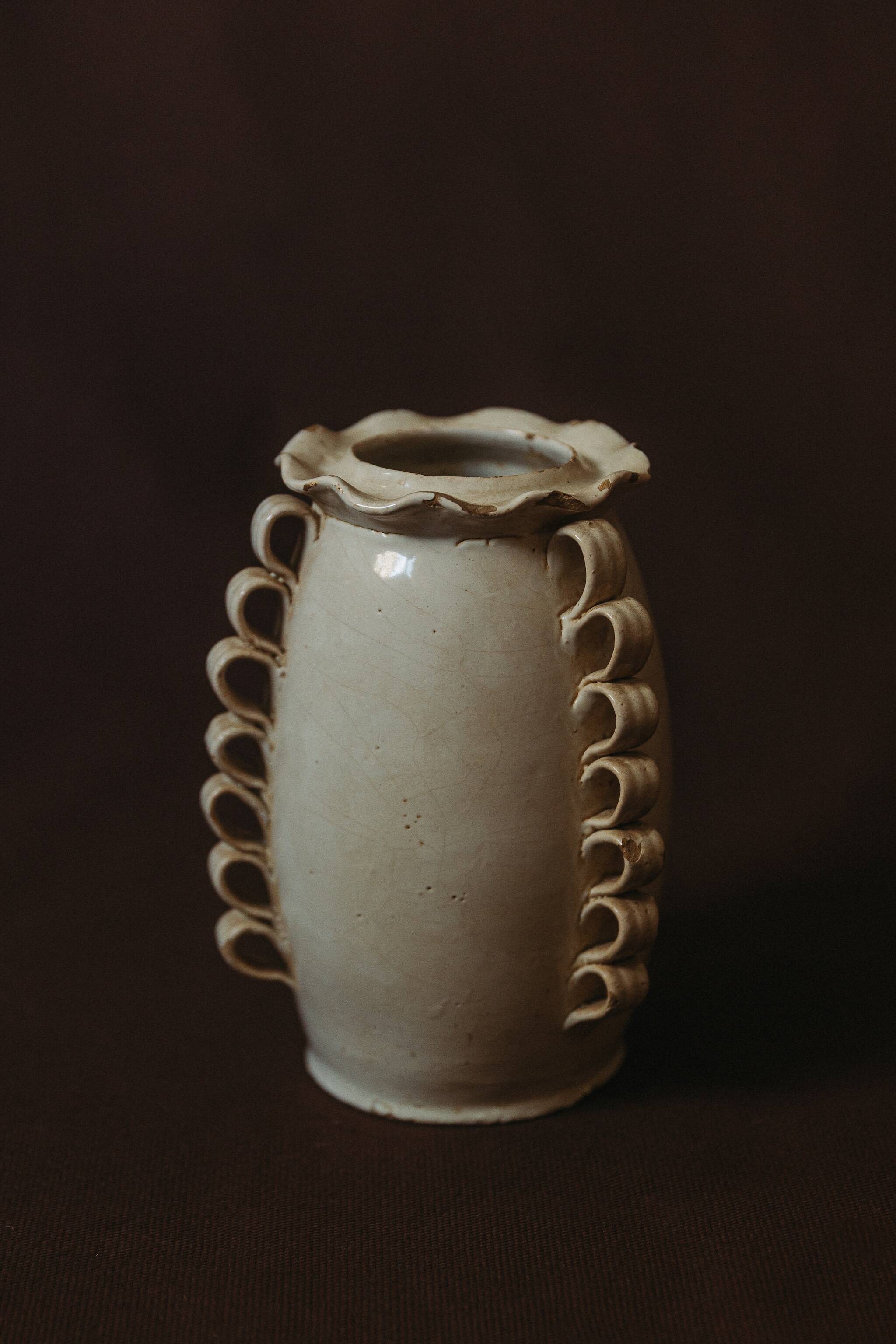 White glazed stoneware vase decorated with raised ribbons.