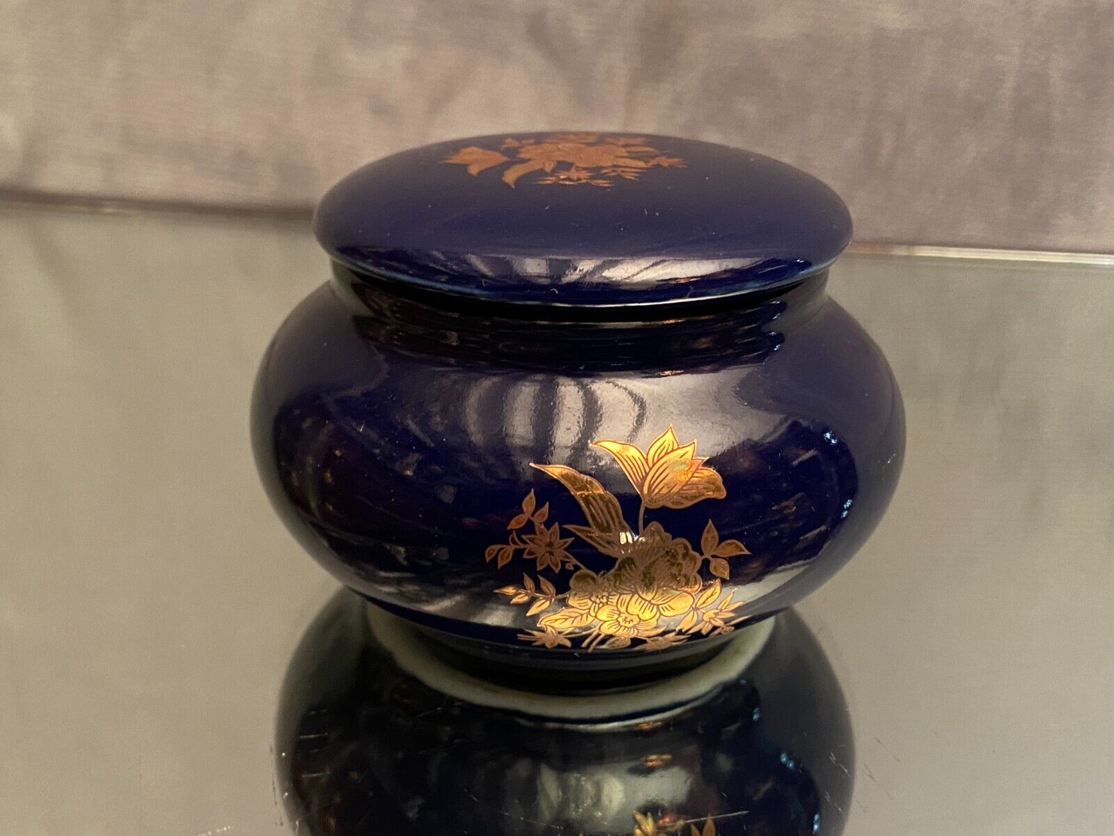 Porcelain candy box with golden floral decoration on a midnight blue background