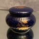 Porcelain candy box with golden floral decoration on a midnight blue background