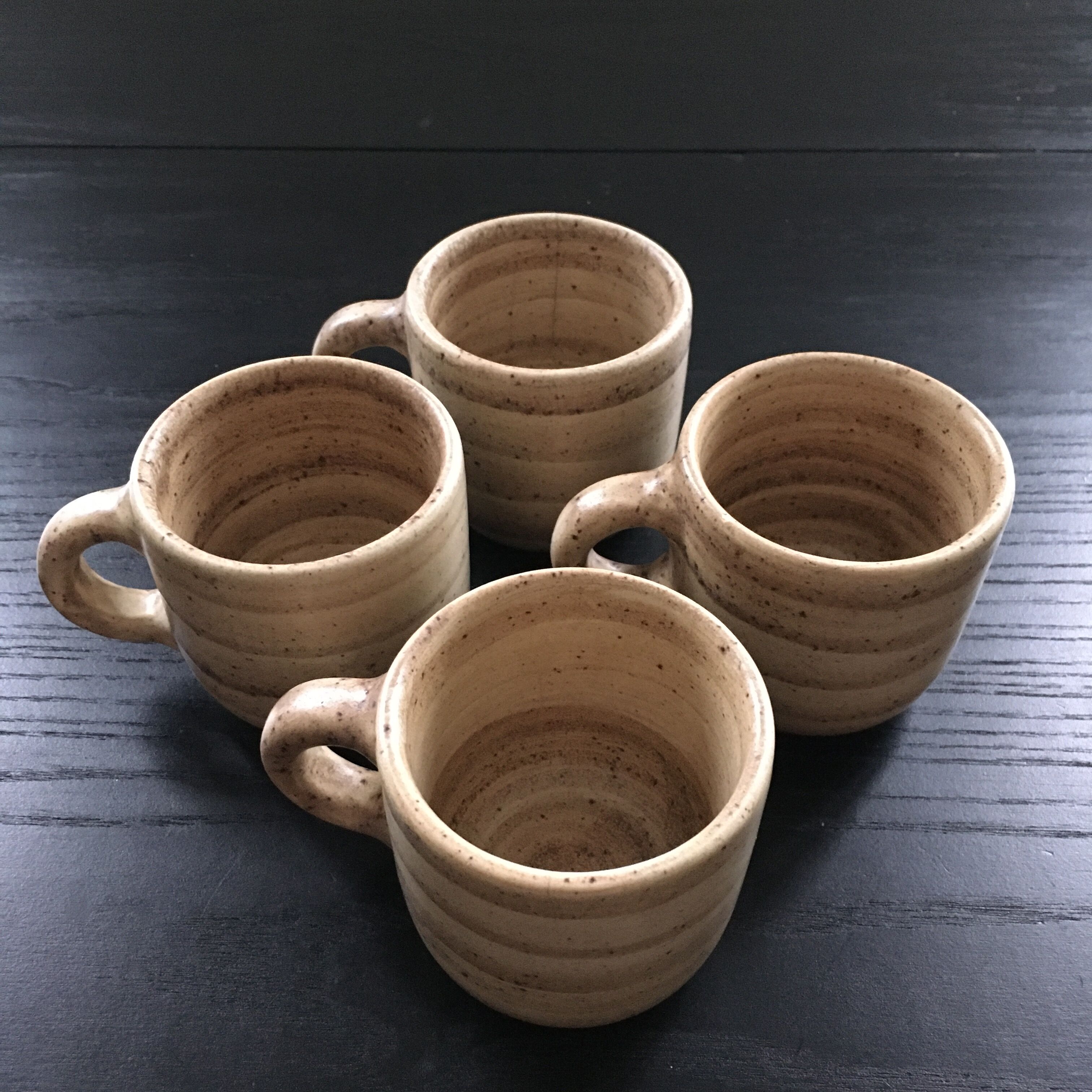 Set of 4 beige stoneware mugs.