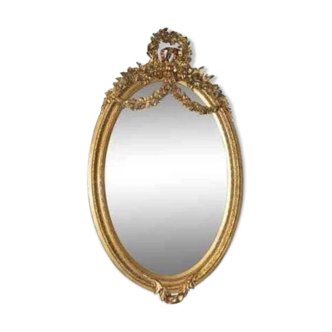 Oval mirror in Louis XVI style in wood and gilded stucco.