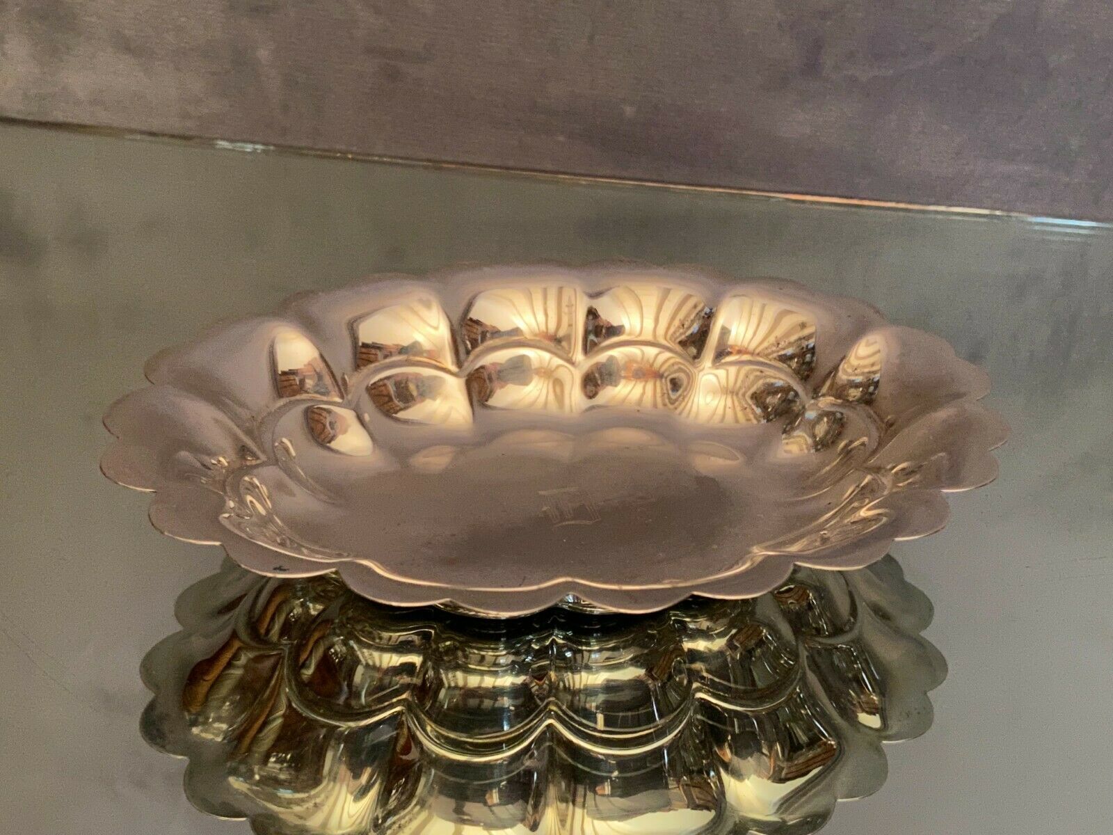 Oval-shaped polylobed metal cup with silver patina engraved with the letter D