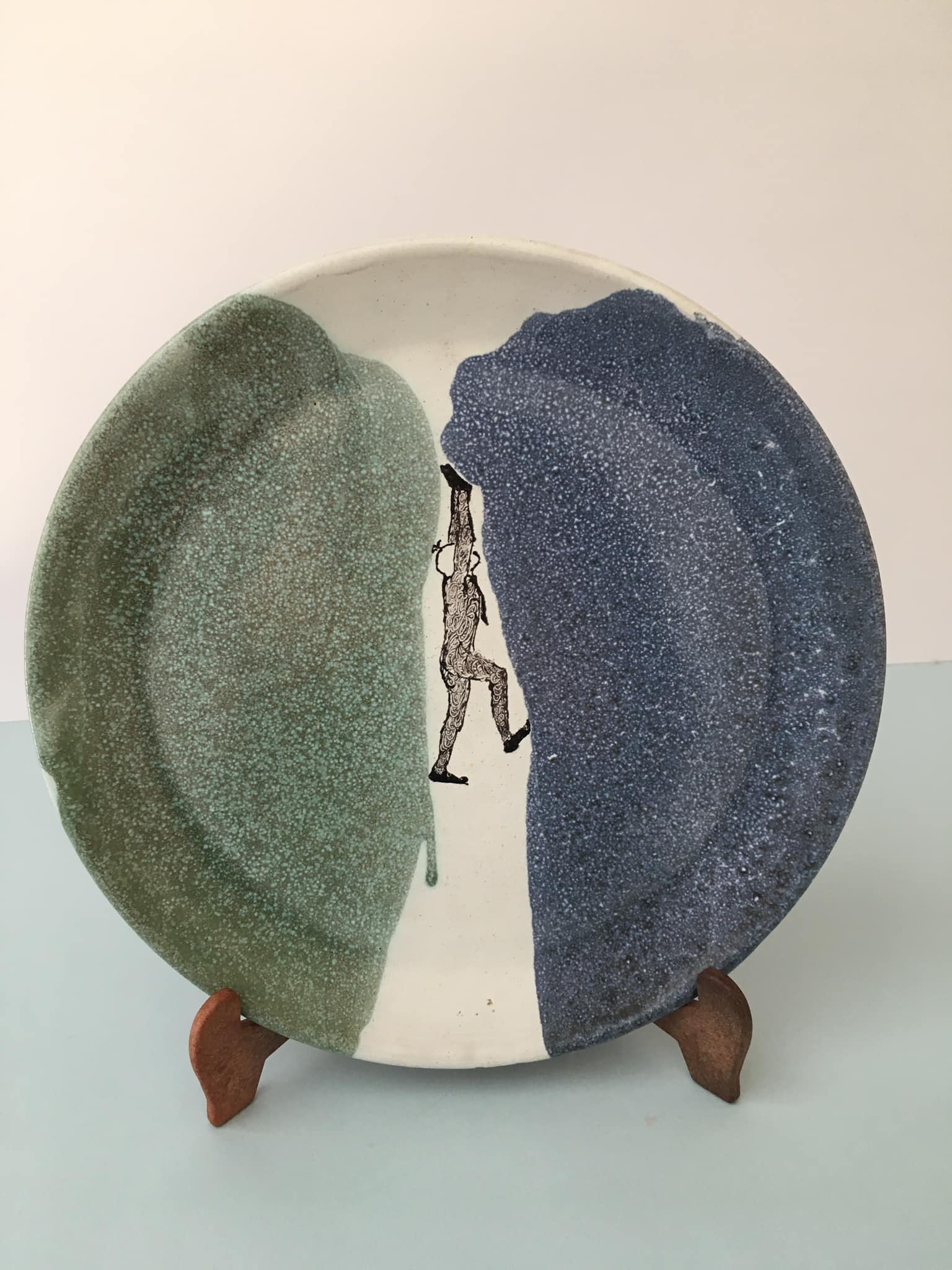 Glazed ceramic plate representation man between two lands unknown signature