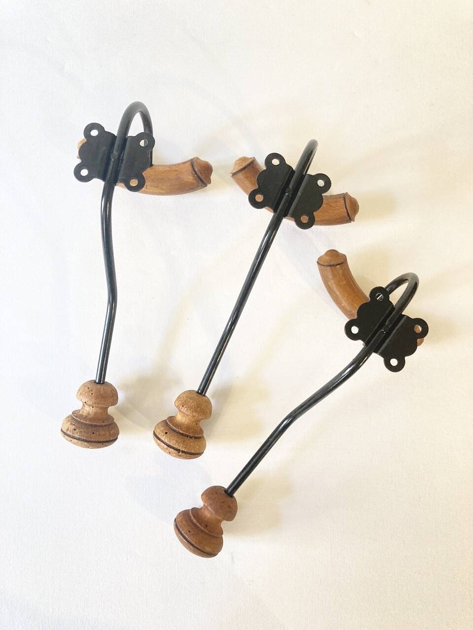 Trio of antique wooden and metal coat hooks