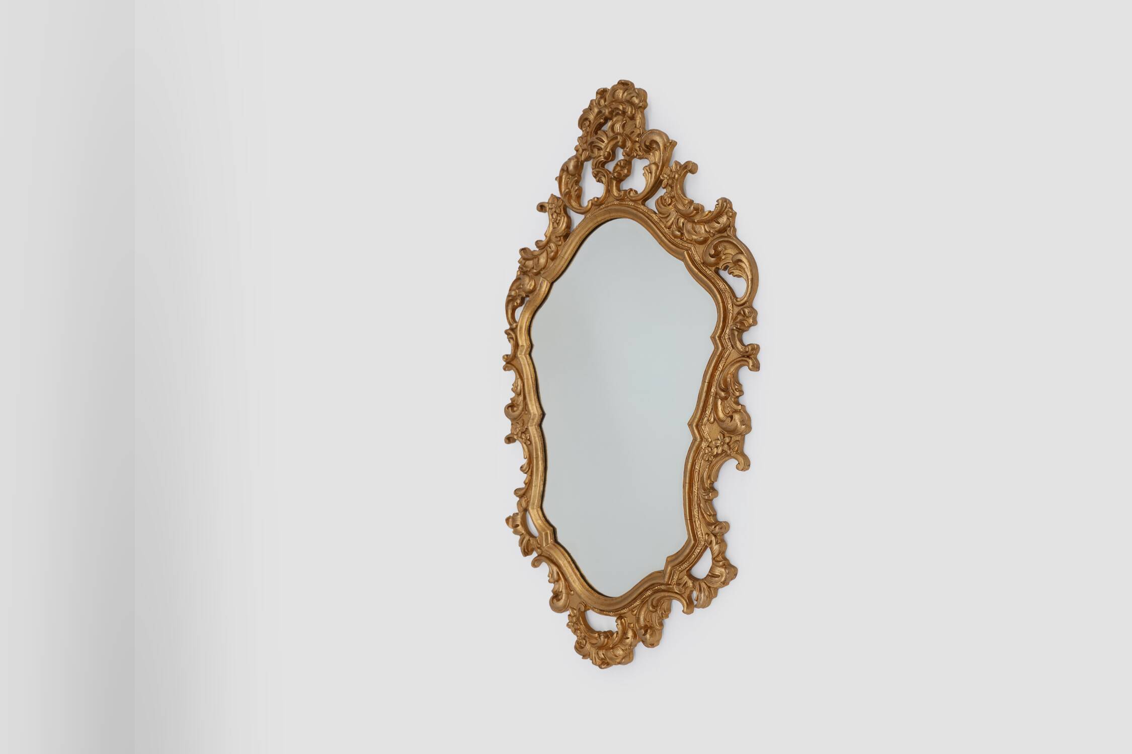 French Rococo or Baroque style facet-cut crest mirror in gilded carved wood