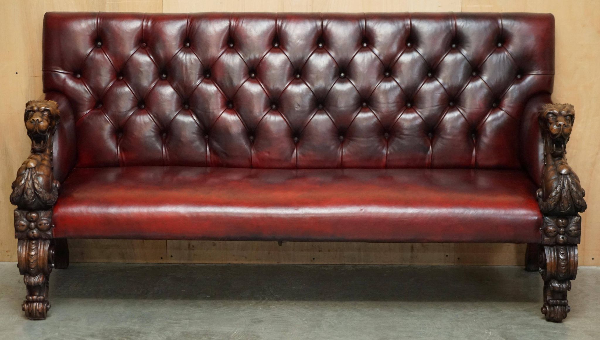 Victorian Chesterfield leather sofa with carved lion heads.