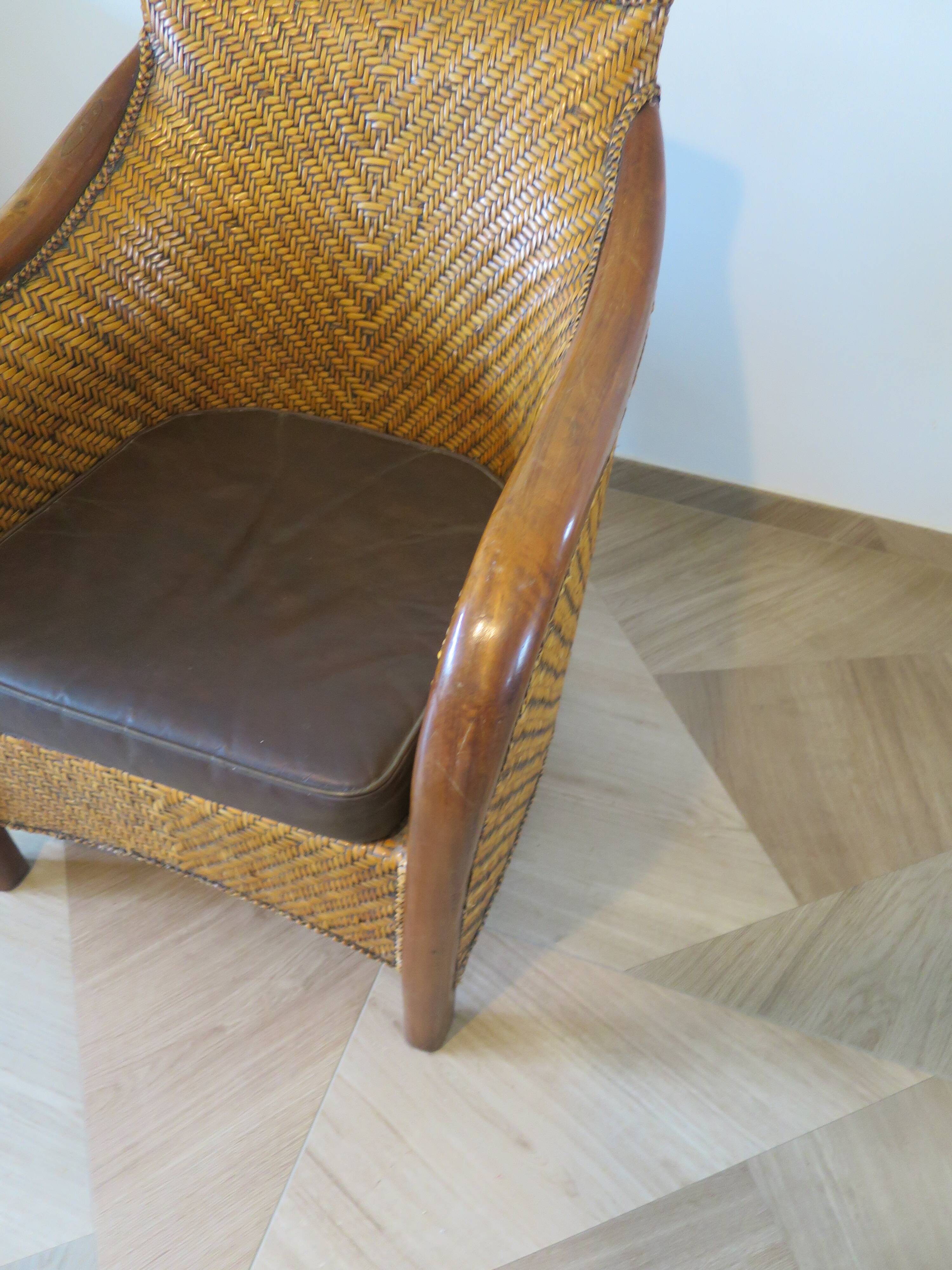 Colonial style armchair in woven rattan and exotic wood