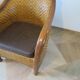 Colonial style armchair in woven rattan and exotic wood