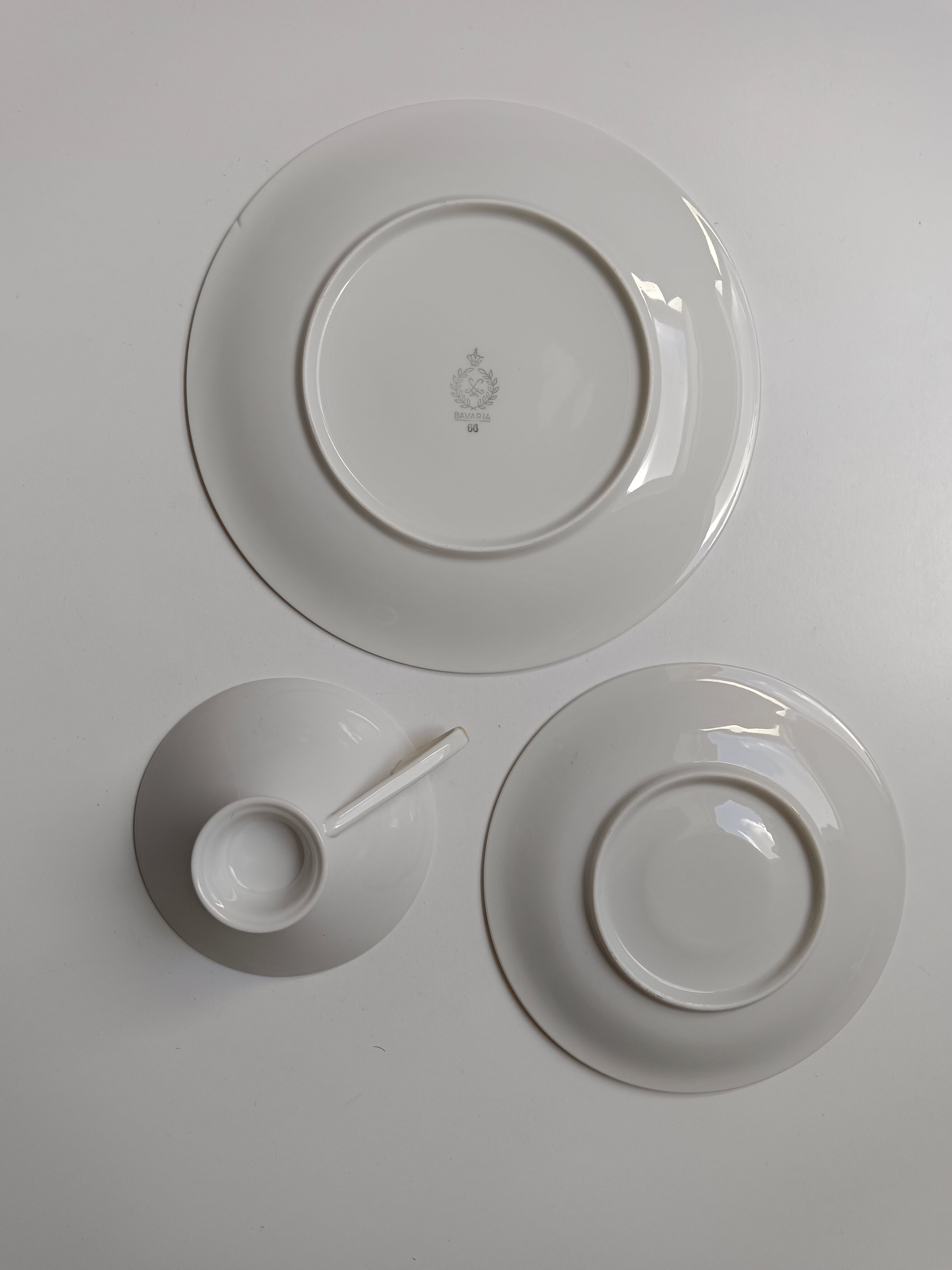 Solitaire tea cup, saucer, and dessert plate in white and gold.