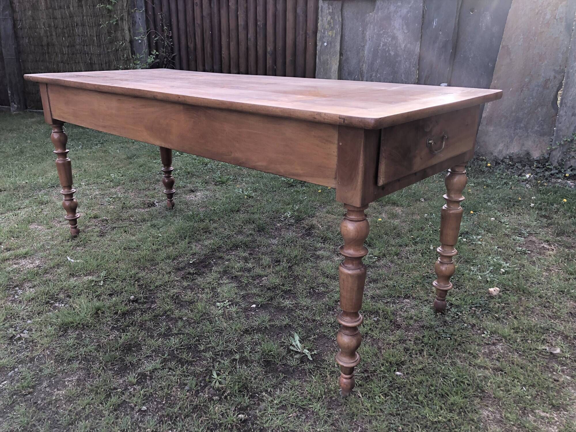 Antique farmhouse table in solid cherry wood with 2 drawers and 1 pull-out at the end with turned legs.