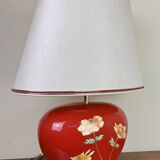 large vintage ceramic lamp with flower decorations on a red background circa 1980