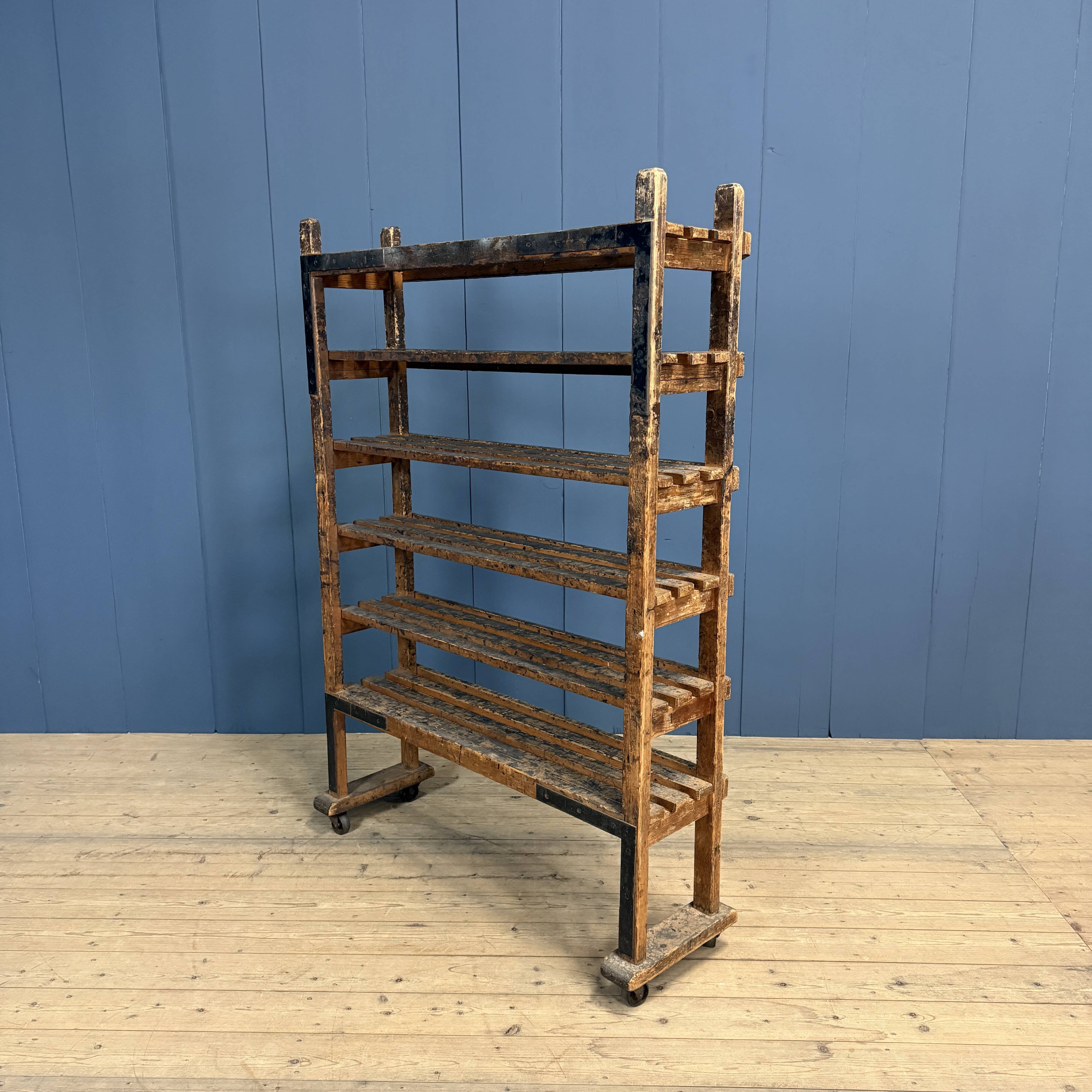 Old wooden workshop shelf with cast iron wheels.