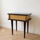 Vintage Art Deco bedside table in dark wood with gold details.