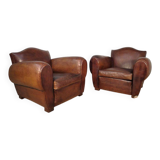 Important pair of Havana leather club armchairs, moustache models, mid-20th century.