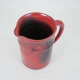 Red glazed ceramic jug with relief