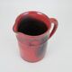 Red glazed ceramic jug with relief
