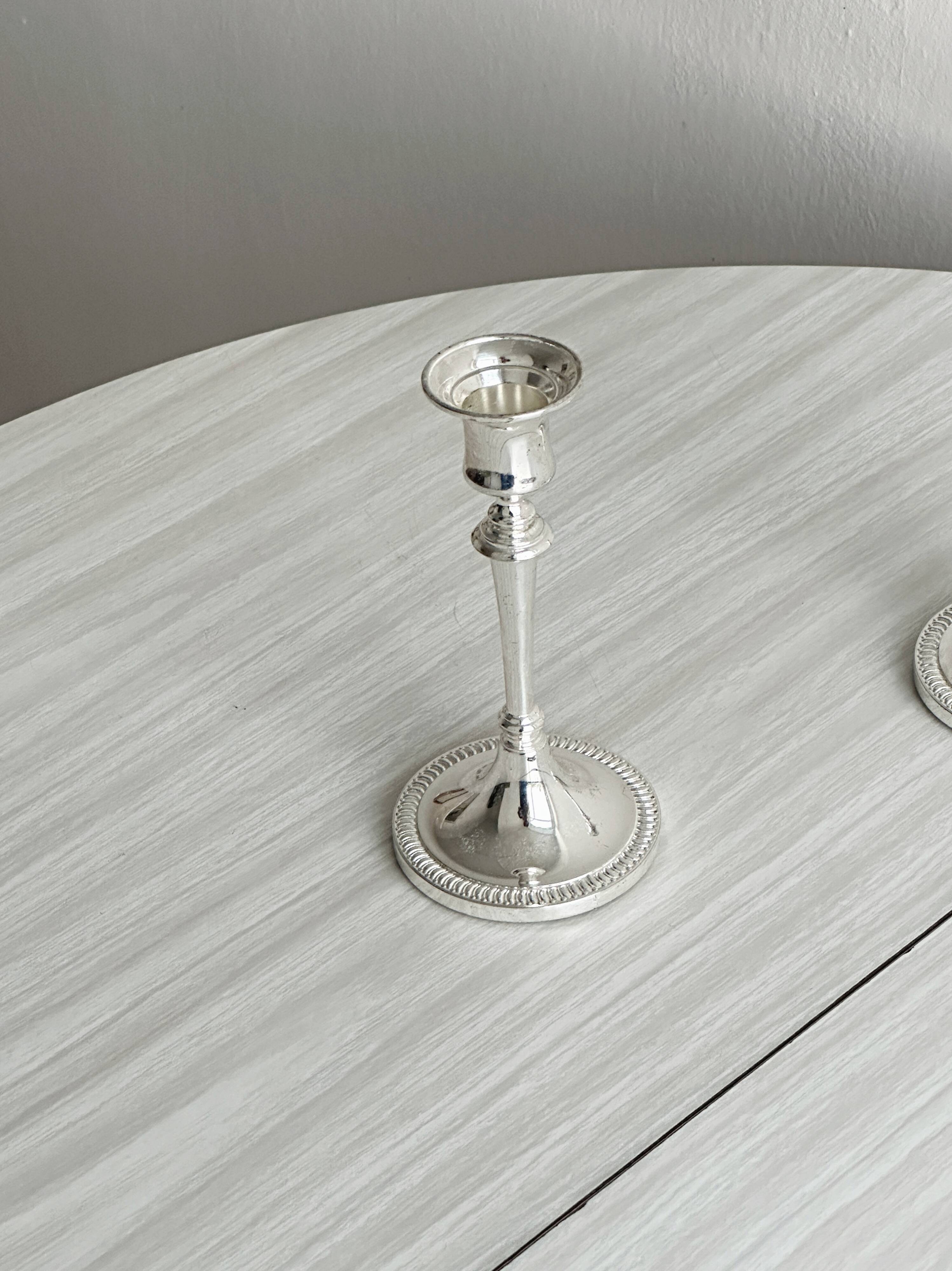 Pair of white metal candlesticks